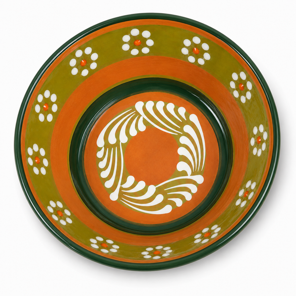 A round ceramic bowl with a hand-painted Mediterranean style design, featuring concentric rings of orange, olive green, and dark green with white floral and leaf patterns, shown on a white background.