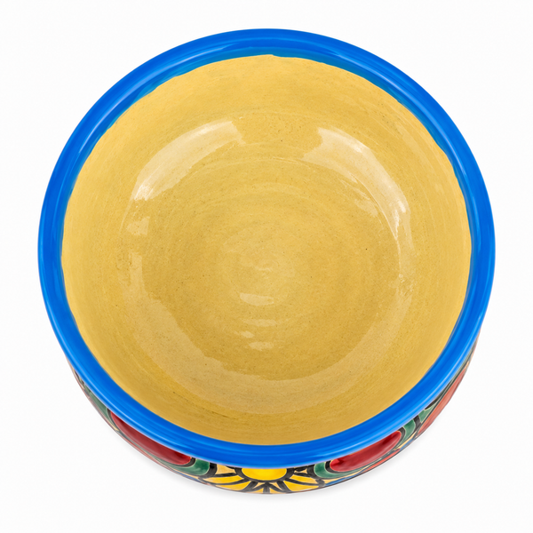 A hand-painted ceramic bowl with a glossy yellow interior, a bright blue rim, and a colorful hand-painted floral pattern at the base, shown from a top-down view on a white background.